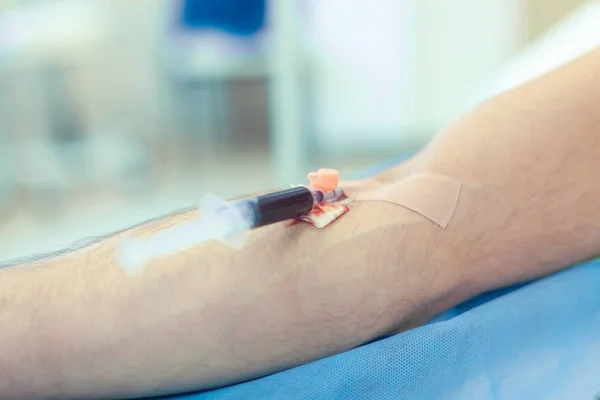 Preparation for surgery. Medical nurse with pink latex gloves inputs catheter to vein patient for drip of chemotherapy or another liquid medicine, jection of propofol to patient for iv anesthesia.