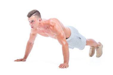 Spor adam beyaz bir arka planda izole Push UPS yapıyor. Güçlü atletik adam-Fitness modeli onun mükemmel vücudu gösteren.