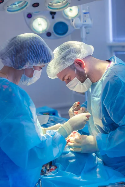 Cirujano y su asistente realizando cirugía estética en la nariz en el quirófano del hospital. Remodelación de la nariz, aumento. Rinoplastia. Martillo . —  Fotos de Stock