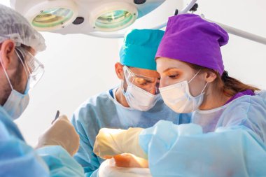 Kellik tedavisi. Saç ekimi. Ameliyathanedeki cerrahlar saç nakli ameliyatı gerçekleştirin. Saç köklerini başın bir kısmından hareket ettiren cerrahi teknik.