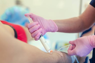 Ameliyat hazırlığı. Pembe lateks eldiven ile tıbbi hemşire, serum kemoterapi veya başka bir sıvı ilaç, IV anestezi için hastaya propofol enjeksiyon damlama için ven hastaya giriş kateter.