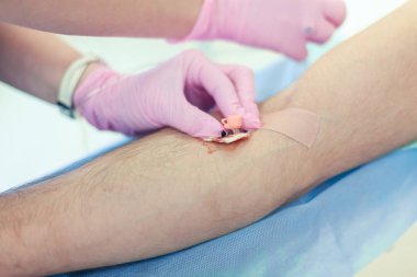 Ameliyat hazırlığı. Pembe lateks eldiven ile tıbbi hemşire, serum kemoterapi veya başka bir sıvı ilaç, IV anestezi için hastaya propofol enjeksiyon damlama için ven hastaya giriş kateter.