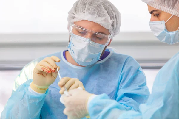 Skallighet behandling. Hårtransplantation. Kirurger i operationssalen utför hår transplantationskirurgi. Kirurgisk teknik som flyttar hårsäckarna från en del av huvudet. — Stockfoto