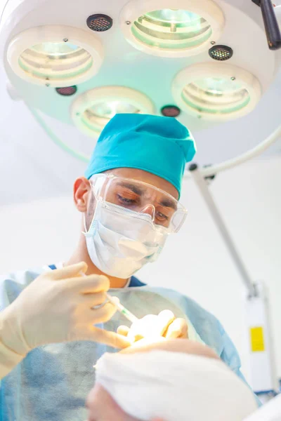 The surgeon gives injections to the head. Baldness treatment. Hair transplant. Surgeons in the operating room carry out hair transplant surgery. Surgical technique that moves hair follicles from a — Stock Photo, Image