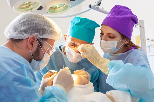 Glatzenbehandlung. Haartransplantation. Chirurgen im Operationssaal führen Haartransplantationen durch. Chirurgische Technik, die Haarfollikel aus einem Teil des Kopfes entfernt. — Stockfoto