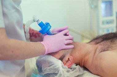 Anestezist operasyon odasında trakeal entübasyonu yapıyor. Ameliyat hazırlığı. Rinoplasti