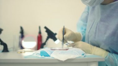 Mikroskop altındaki doktor saç köklerini yeniden hesaplar. Kellik tedavisi. Saç ekimi. Ameliyathanedeki cerrahlar saç nakli ameliyatı gerçekleştirin. Hareket eden cerrahi teknik