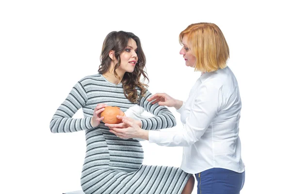 Une jeune femme enceinte est formée par un obstétricien pour allaiter un bébé à naître. Apprendre sur la disposition de l'enfant . — Photo