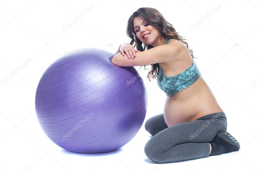 Portrait of a beautiful young pregnant woman exercises with fitball. Working out and fitness, pregnancy concept. Isolated white background.