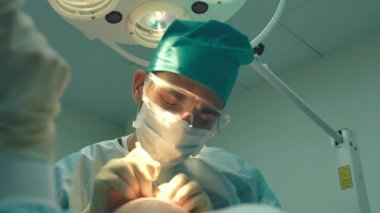 Kellik tedavisi. Saç ekimi. Ameliyathanedeki cerrahlar saç nakli ameliyatı gerçekleştirin. Saç köklerini başın bir kısmından hareket ettiren cerrahi teknik.