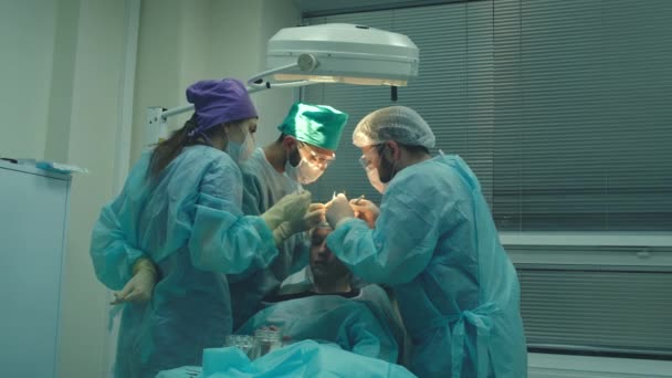 Skallighet behandling. Hårtransplantation. Kirurger i operationssalen utför hår transplantationskirurgi. Kirurgisk teknik som flyttar hårsäckarna från en del av huvudet. — Stockvideo