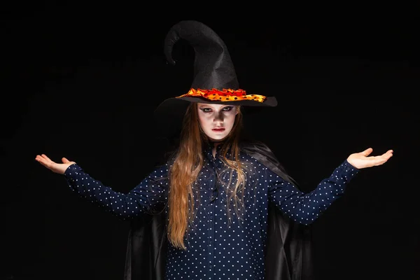 Halloween Witch on black background. Beautiful young surprised woman in witches hat and costume. Wide Halloween party art design. Copy-paste. The concept of scales, offers to choose gifts, place items — Stock Photo, Image