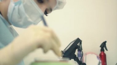 Mikroskop altındaki doktor saç köklerini yeniden hesaplar. Kellik tedavisi. Saç ekimi. Ameliyathanedeki cerrahlar saç nakli ameliyatı gerçekleştirin. Hareket eden cerrahi teknik
