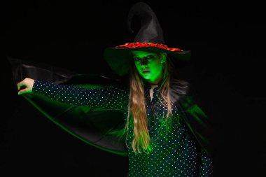 Yeşil parlayan sıvı bir tencere üzerinde Halloween Witch siyah arka plan üzerinde eller conjures. Cadılar şapka ve kostüm güzel genç sürpriz kadın . Geniş Cadılar Bayramı parti sanat tasarımı. Kopyala-yapıştır. Cadı