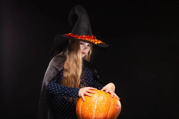 Sorcière d'Halloween avec citrouille sur fond noir. Belle jeune femme surprise en chapeau de sorcières et costume tenant citrouille. Design d'art de fête Halloween large. Copier-coller. Concept de sorcière. Araignée — Photo