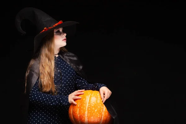 Sorcière d'Halloween avec citrouille sur fond noir. Belle jeune femme surprise en chapeau de sorcières et costume tenant citrouille. Design d'art de fête Halloween large. Copier-coller. Concept de sorcière. Araignée — Photo