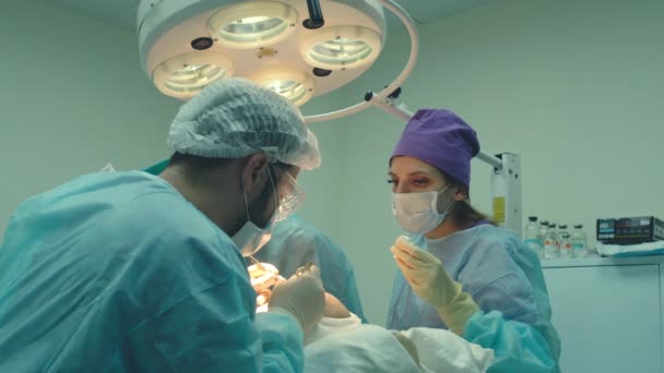 Traitement de calvitie. Une greffe de cheveux. Les chirurgiens dans la salle d'opération effectuent une greffe de cheveux. Technique chirurgicale qui déplace les follicules pileux d'une partie de la tête . — Video