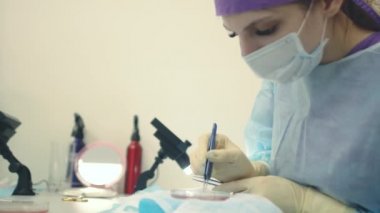 Mikroskop altındaki doktor saç köklerini yeniden hesaplar. Kellik tedavisi. Saç ekimi. Ameliyathanedeki cerrahlar saç nakli ameliyatı gerçekleştirin. Hareket eden cerrahi teknik