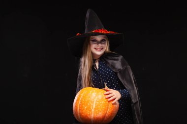 Siyah arka planda Balkabağı ile Halloween Witch. Cadılar şapka ve kostüm balkabağı tutan güzel genç sürpriz kadın. Geniş Cadılar Bayramı parti sanat tasarımı. Kopyala-yapıştır. Cadı zanaat konsepti. Örümcek