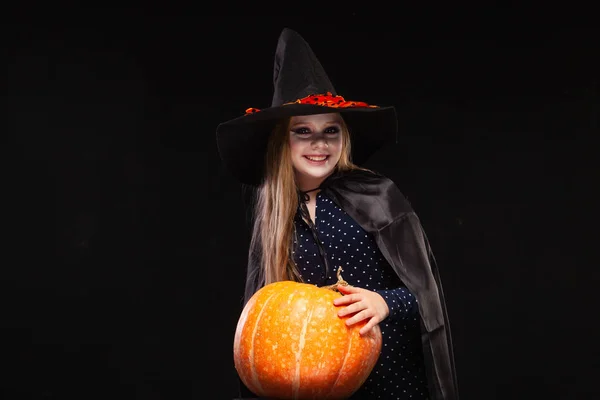 Halloween boszorkány sütőtök a fekete háttér. Gyönyörű fiatal meglepett nő boszorkányok kalap és jelmez gazdaság sütőtök. Széles Halloween Party Art Design. Copy-beillesztés. Boszorkány kézműves koncepció. Pók — Stock Fotó