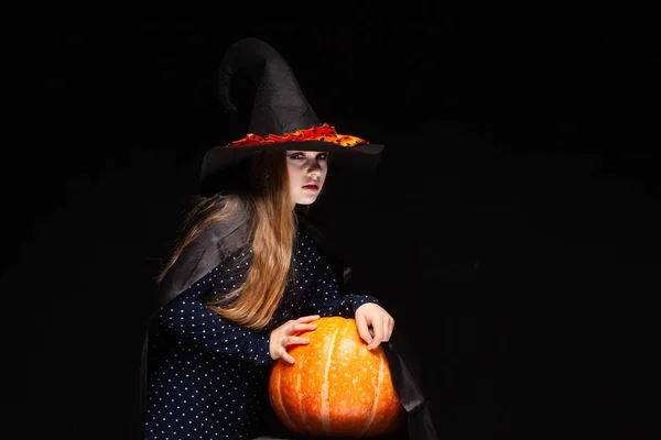Halloween häxa med pumpa på svart bakgrund. Vacker ung förvånad kvinna i Witches hatt och kostym Holding Pumpkin. Bred Halloween fest konst design. Kopiera och klistra in. Witch Craft Concept. Spider — Stockfoto