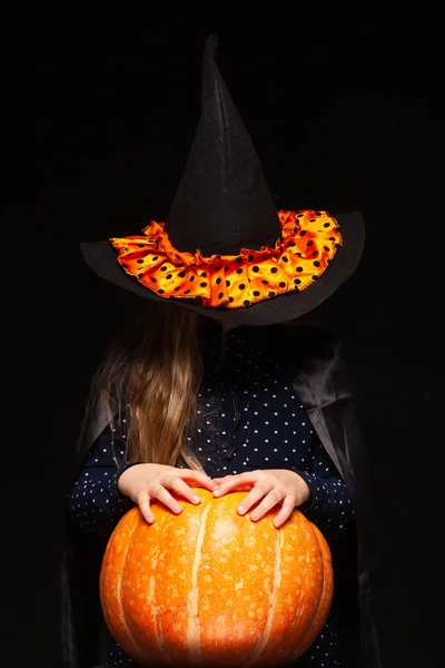 Halloween Witch with Pumpkin on black background. Beautiful young surprised woman in witches hat and costume holding pumpkin. Wide Halloween party art design. Copy-paste. Witch craft concept. Spider — Stock Photo, Image