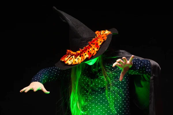 Halloween-Hexe über einem Topf mit grün glühender Flüssigkeit zaubert Hände auf schwarzem Hintergrund. schöne junge überraschte Frau mit Hexenhut und Kostüm. breit halloween party art design. Copy-Paste. Hexe — Stockfoto