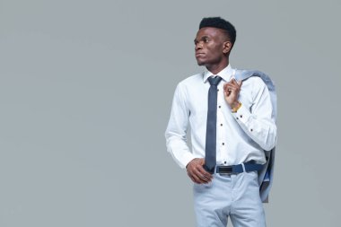 Genç siyah adam. Portre başarılı gülümseyen neşeli afrikalı-amerikalı işadamı yönetici şık şirket lideri. Gri arka planda yalıtılmış.