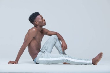 Genç siyah adam. Portre başarılı gülümseyen neşeli afrikalı-amerikalı işadamı yönetici şık şirket lideri. Çıplak gövde ile Fitness modeli. Abs. Gri arka planda izole.