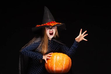 Siyah arka plan üzerinde Kabak ile Halloween Witch elleriyle bir büyü casts. Cadılar şapka ve kostüm balkabağı tutan güzel genç sürpriz kadın. Geniş Cadılar Bayramı parti sanat tasarımı. Kopyala-yapıştır