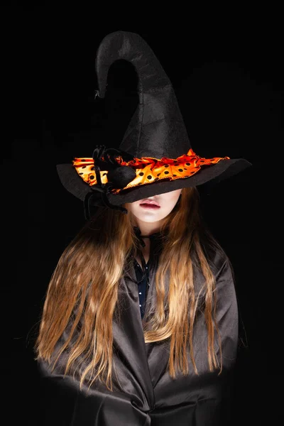 Halloween. Boszorkány egy pók a kalapját a fekete háttér. Gyönyörű fiatal meglepett nő boszorkányok kalap és jelmez gazdaságban. Széles Halloween Party Art Design. Copy-beillesztés. Witch Craft koncepció — Stock Fotó
