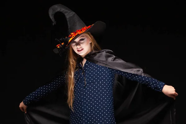 Halloween. Bruja con una araña en su sombrero sobre fondo negro. Hermosa joven sorprendida mujer en sombrero de brujas y la celebración del traje. Amplia fiesta de Halloween diseño de arte. Copia y pega. Concepto de bruja —  Fotos de Stock