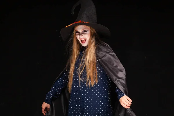 Halloween. Bruja con una araña en su sombrero sobre fondo negro. Hermosa joven sorprendida mujer en sombrero de brujas y la celebración del traje. Amplia fiesta de Halloween diseño de arte. Copia y pega. Concepto de bruja —  Fotos de Stock