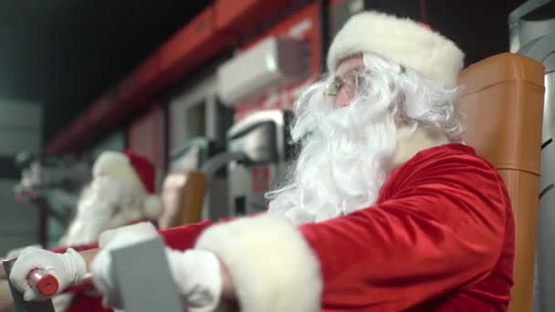 サンタクロースはクリスマスの日にジムでトレーニング — ストック動画