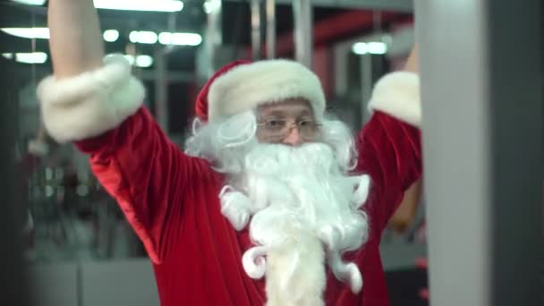 Treinamento de Papai Noel no ginásio no dia de Natal. exercício-máquina . — Vídeo de Stock