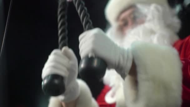 Santa Claus entrenando en el gimnasio el día de Navidad. Santa Claus trabajando haciendo ejercicios en tríceps . — Vídeo de stock