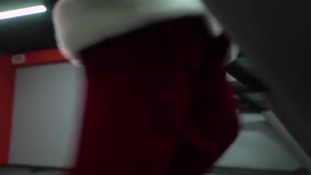 Santa Claus entrenando en el gimnasio el día de Navidad. Santa Claus corriendo en la cinta de correr de la máquina en el gimnasio club — Vídeo de stock