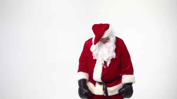 Natale. Babbo Natale su uno sfondo bianco indossa guanti da boxe neri e compie pugni. Kickboxing, combattente . — Video Stock