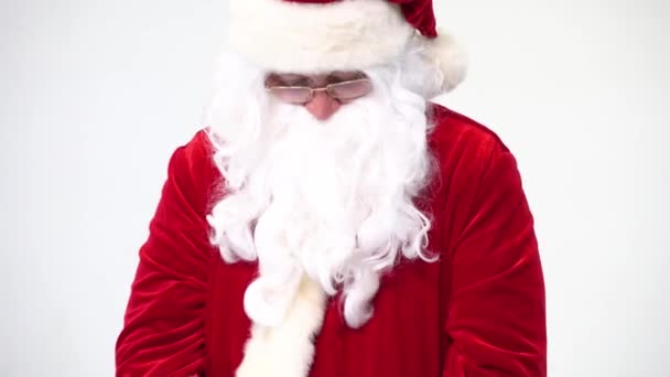 Санта Клаус на белом фоне с красным ведром попкорна. Ест попкорн и смотрит кино, предлагает попкорн . — стоковое видео