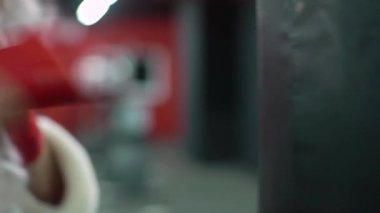 Noel Baba Dövüşçüsü Kırmızı Bandaj boksörüyle kickbox bir boks stüdyosunda büyük bir kum torbasına vuruyor. Noel Baba boksörü sıkı çalışıyor..