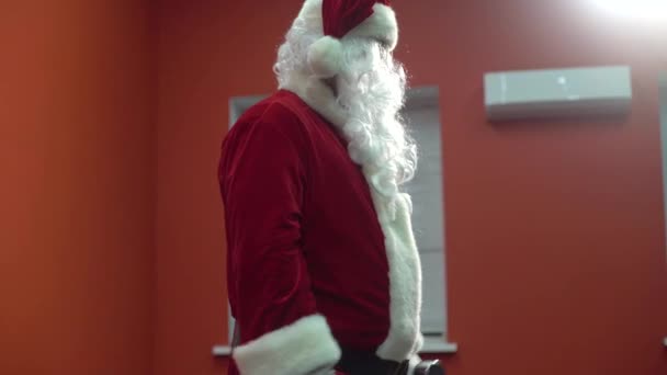 Jultomten tränar på gymmet på juldagen. Jultomten tränar med hantlar. — Stockvideo
