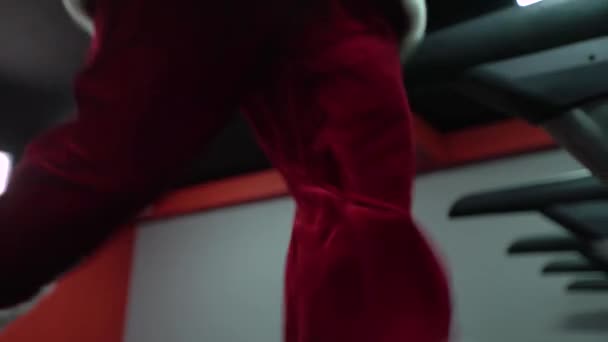 Santa Claus entrenando en el gimnasio el día de Navidad. Santa Claus corriendo en la cinta de correr de la máquina en el gimnasio club — Vídeos de Stock