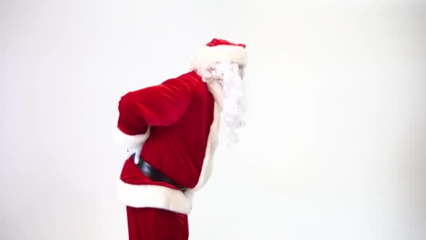 Santa Claus sobre un fondo blanco sufre de dolor de espalda, atormentado, camina inclinado. Hernia intervertebral, protrusión . — Vídeo de stock