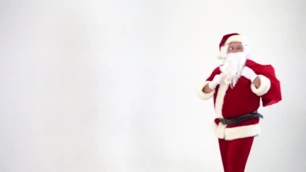 Χριστούγεννα. Άγιος Βασίλης σε λευκό φόντο παίρνει ένα κόκκινο κουτί με ένα τόξο από μια τσάντα, δίνει. Παρών. Έκπληξη. — Αρχείο Βίντεο