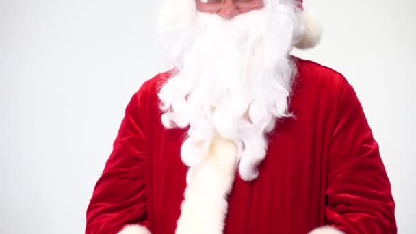 Santa Claus na bílém pozadí s červeným kbelíkem popcornu. Jí popcorn a kouká na film, nabízí popcorn. — Stock video