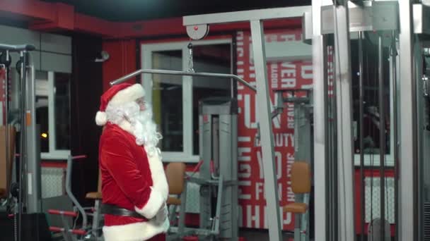 Weihnachtsmann-Training an Weihnachten in der Turnhalle. Trainingsgerät. — Stockvideo