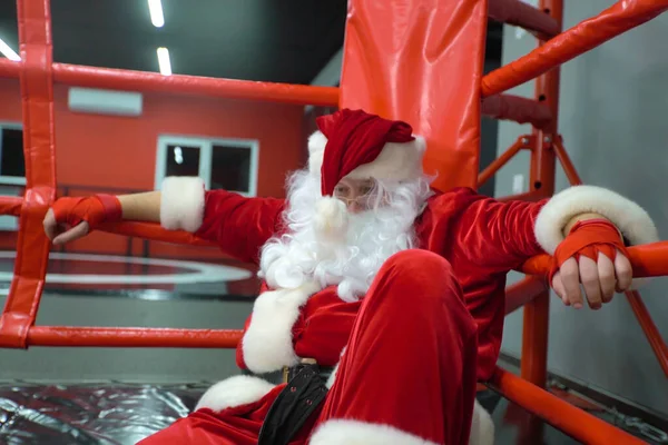 Kickbox Santa Claus Fighter z czerwonymi bandażami na ringu. Santa Claus bokser trening ciężko. — Zdjęcie stockowe