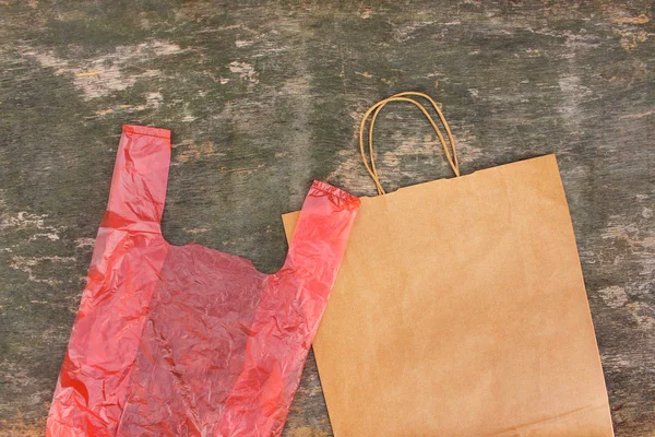 Two different bags of paper and polyethylene on an old wooden ba