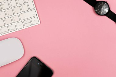 Bilgisayar klavyesi ve diğer ofis malzemeleri ile pembe ofis masası arka plan. Kopyalama alanı ile üst görünüm, düz döşeme.