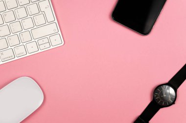 Bilgisayar klavyesi ve diğer ofis malzemeleri ile pembe ofis masası arka plan. Kopyalama alanı ile üst görünüm, düz döşeme.